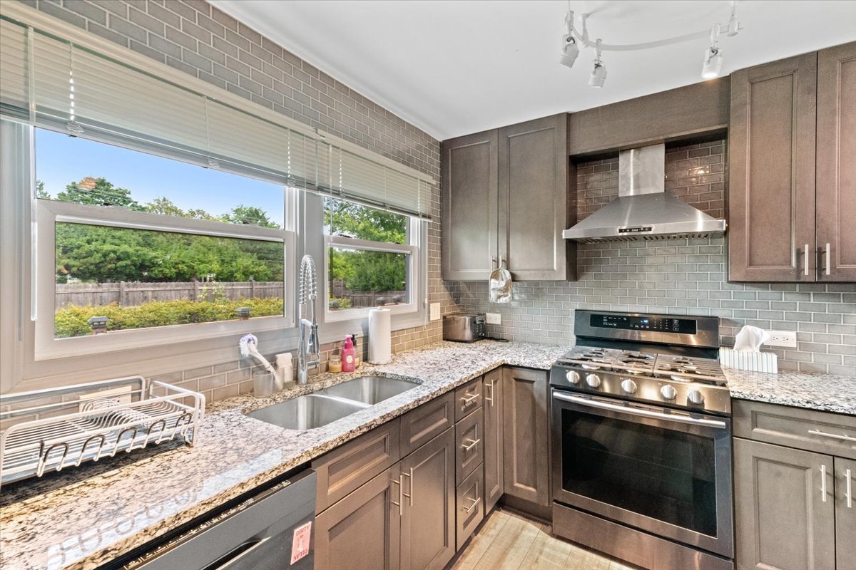 1011 Aspen Drive Buffalo Grove, IL 60089 - Photo 5 of 19 a kitchen with granite countertop a sink stainless steel appliances and a window