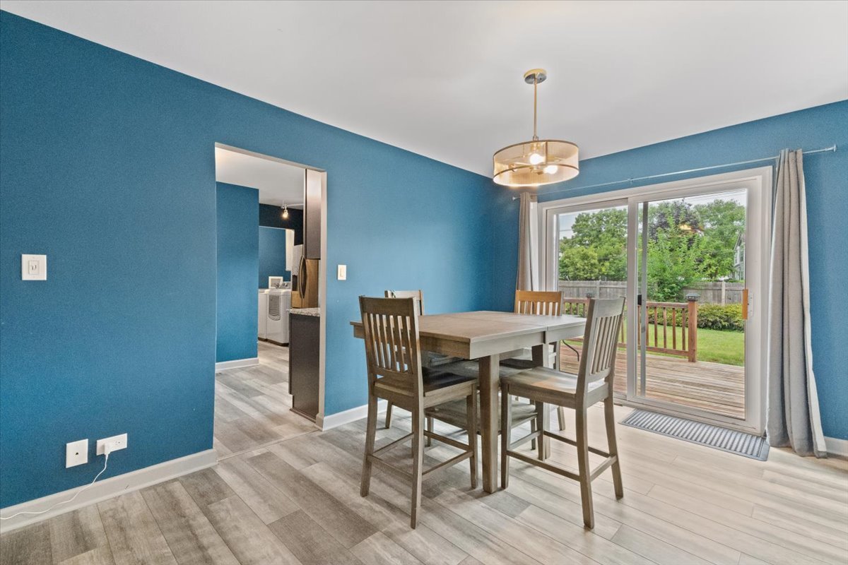 1011 Aspen Drive Buffalo Grove, IL 60089 - Photo 8 of 19 a dining room with wooden floor a chandelier a wooden table and chairs