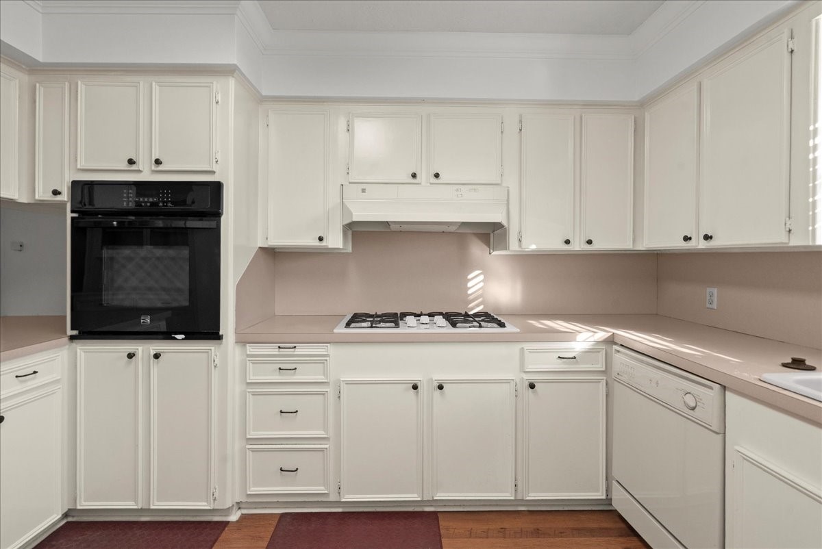 105 Alice Street Anahuac, TX 77514 - Photo 8 of 39 a kitchen with white cabinets and appliances