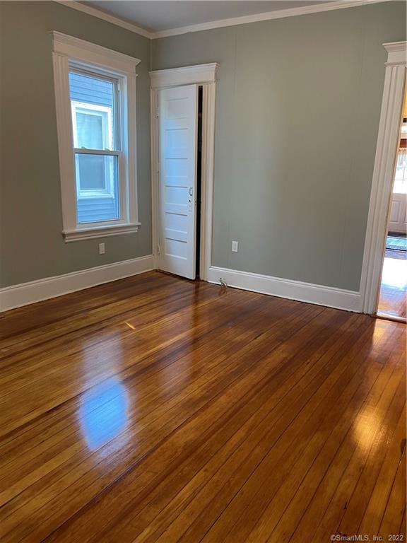 115 Oak Street, Unit 1 Bridgeport, CT 06604 - Photo 11 of 19 an empty room with wooden floor and windows