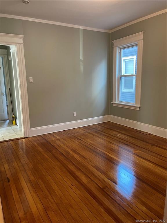115 Oak Street, Unit 1 Bridgeport, CT 06604 - Photo 12 of 19 a view of an empty room with wooden floor and a window