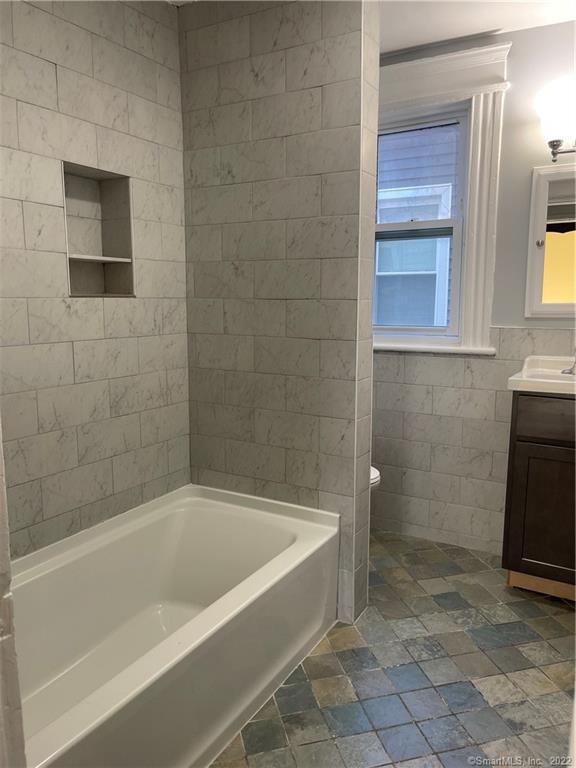 115 Oak Street, Unit 1 Bridgeport, CT 06604 - Photo 13 of 19 a bath tub sitting next to a bathroom sink