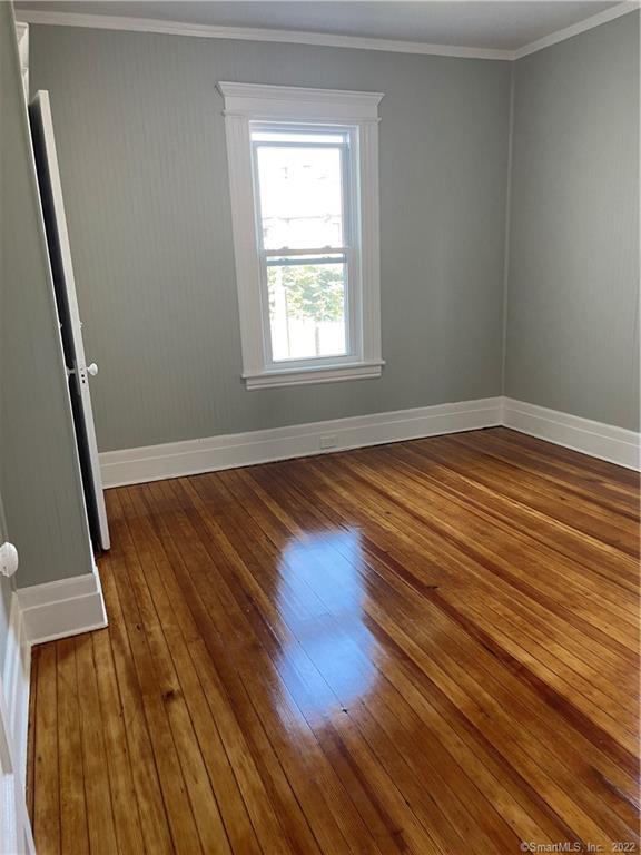 115 Oak Street, Unit 1 Bridgeport, CT 06604 - Photo 14 of 19 a view of an empty room with wooden floor and a window