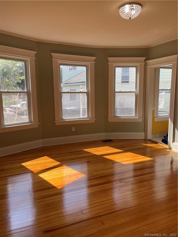 115 Oak Street, Unit 1 Bridgeport, CT 06604 - Photo 18 of 19 a view of empty room with wooden floor and fan