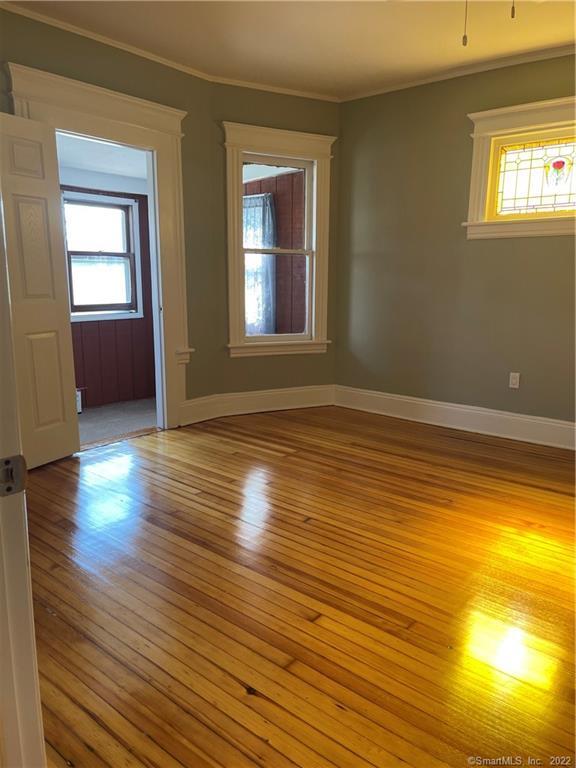 115 Oak Street, Unit 1 Bridgeport, CT 06604 - Photo 8 of 19 a view of empty room with wooden floor and fan