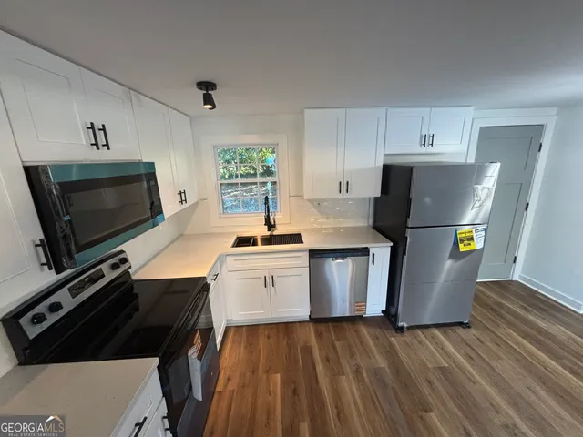 a kitchen with a sink appliances and cabinets