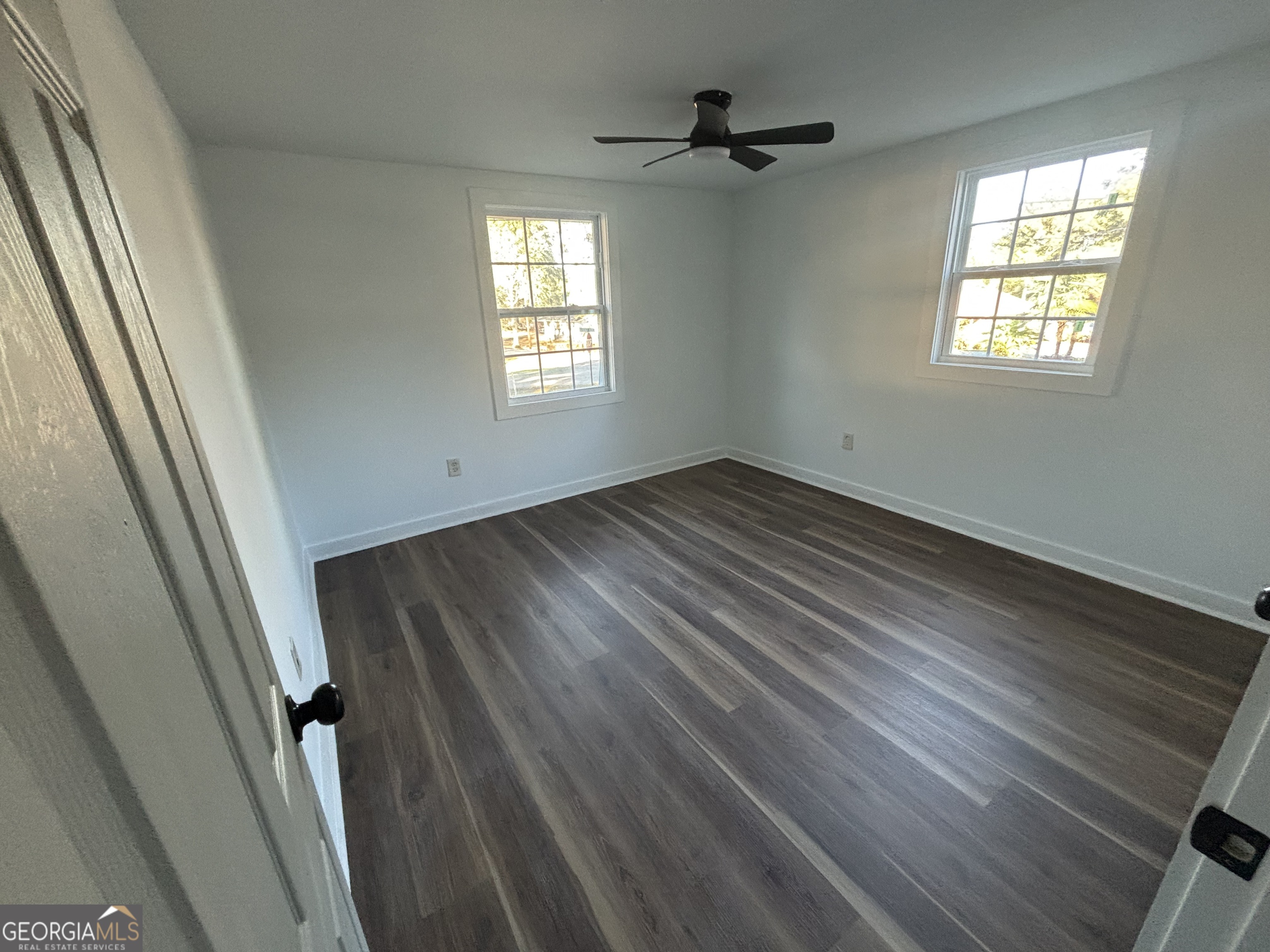176 Randall Avenue Flovilla, GA 30216 - Photo 23 of 32 a view of an empty room with wooden floor and a window