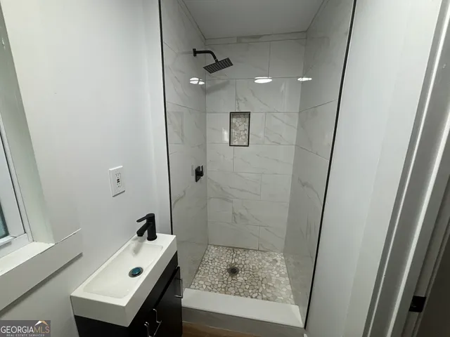 a bathroom with a sink a toilet and shower