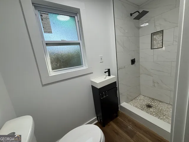 a bathroom with a toilet sink and shower