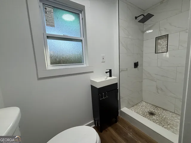 a bathroom with a toilet a sink and shower