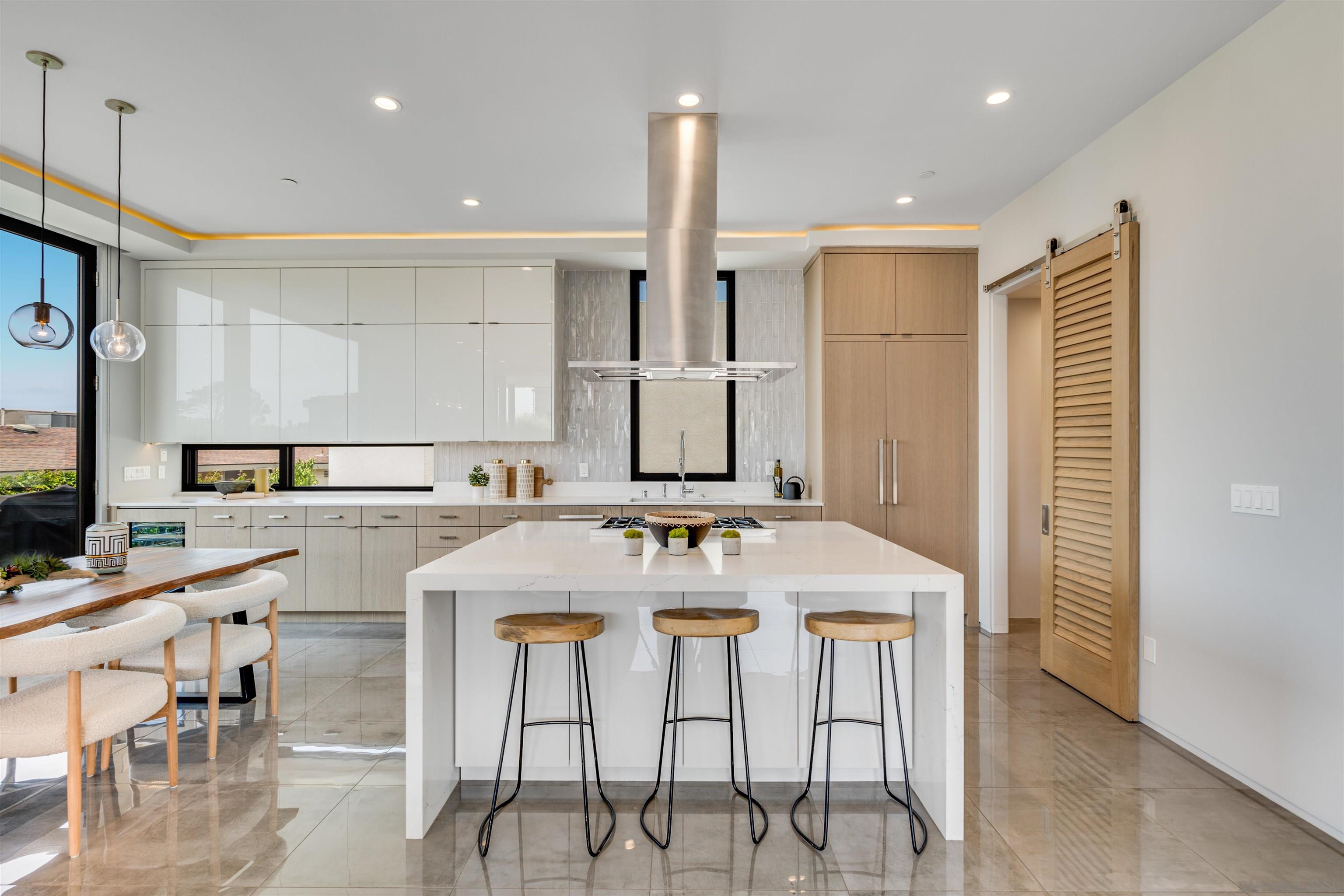 320 11th Street Del Mar, CA 92014 - Photo 10 of 45 a kitchen with stainless steel appliances kitchen island granite countertop a table chairs sink and cabinets