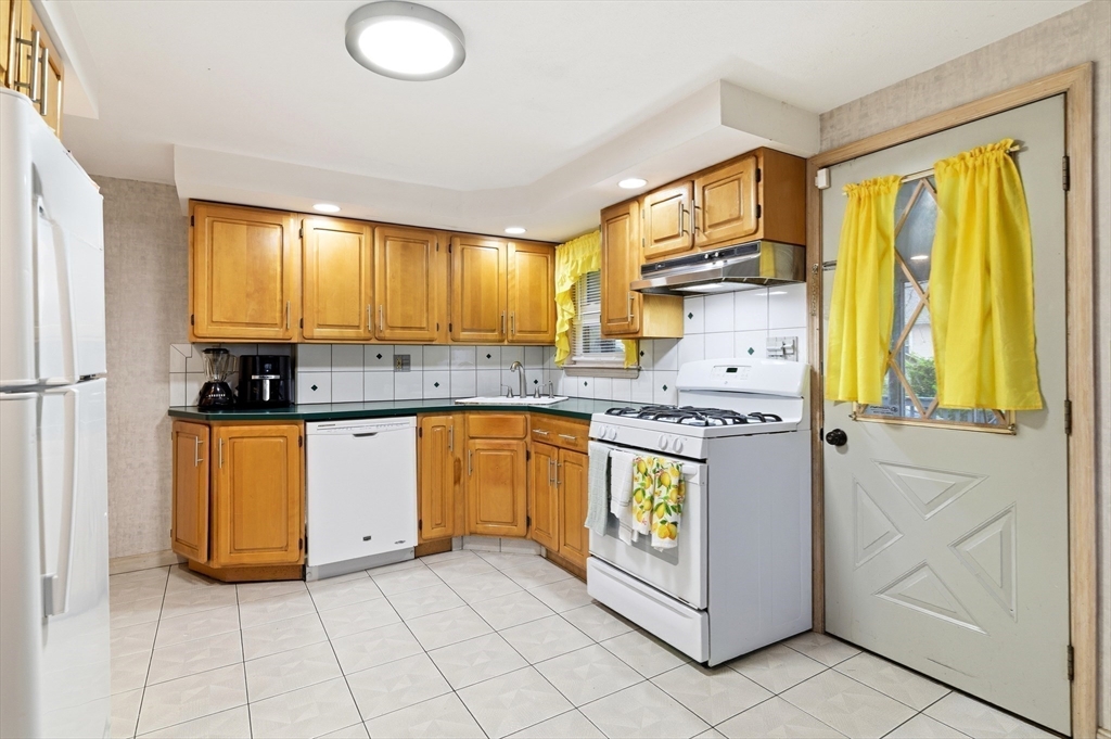 19 Clark Street Randolph, MA 02368 - Photo 11 of 30 a kitchen with stainless steel appliances granite countertop a stove a sink and a refrigerator