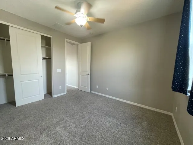 an empty room with a ceiling fan and a window