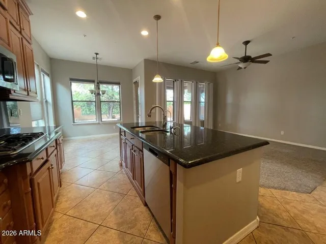 a kitchen with granite countertop a sink a counter top space stove and cabinets