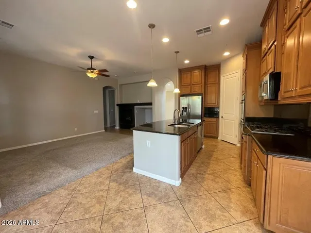 a large kitchen with stainless steel appliances kitchen island granite countertop a stove a sink and a microwave
