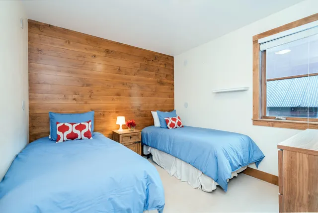 a bedroom with two beds and a large window