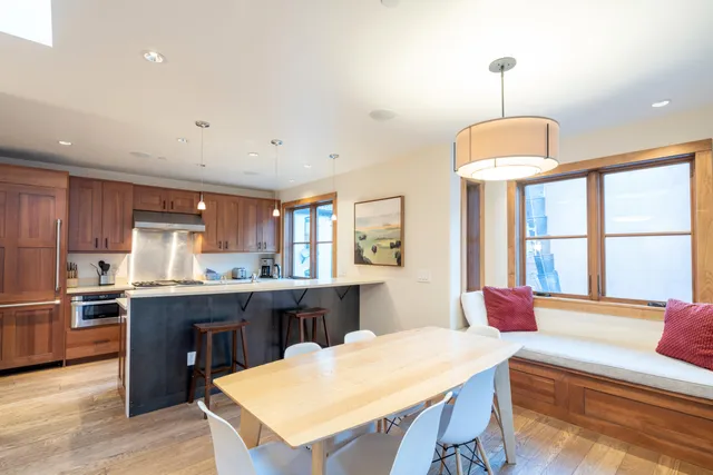 a large kitchen with kitchen island a dining table and a large window