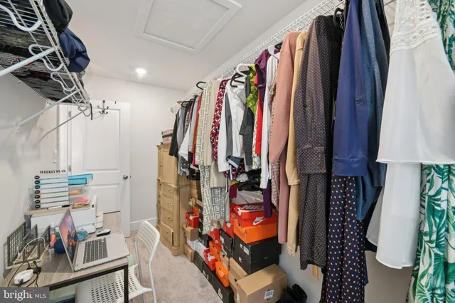 a view of walk in closet with clothes and shoes