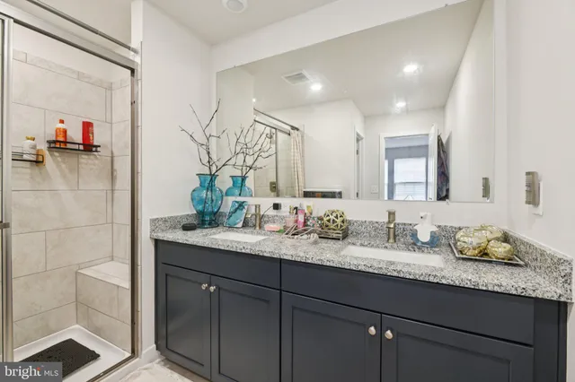 a bathroom with a granite countertop sink and a mirror