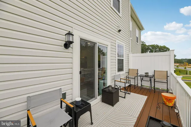 a view of a balcony with wooden floor next to a yard