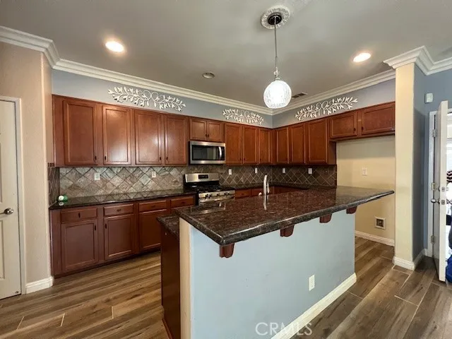 a kitchen with stainless steel appliances granite countertop a sink refrigerator and cabinets