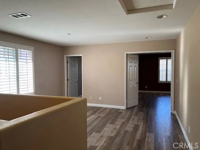 a view of a livingroom with wooden floor and a ceiling fan