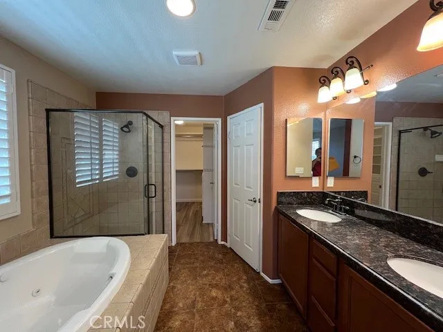 a spacious bathroom with a granite countertop tub sink and shower