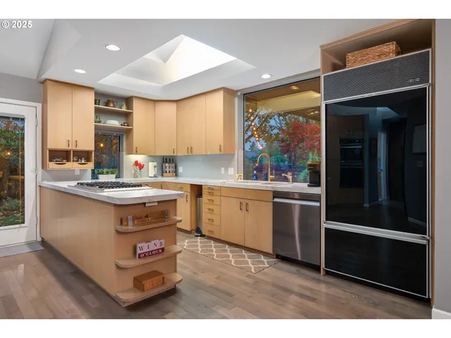 a kitchen with kitchen island granite countertop a stove refrigerator and sink