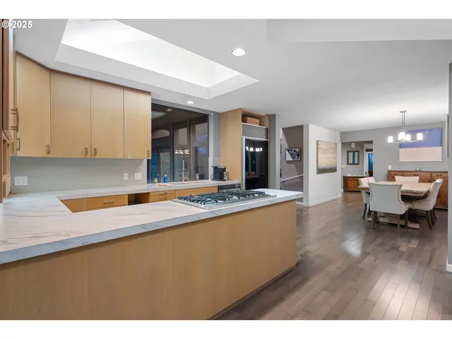 a large kitchen with stainless steel appliances granite countertop a lot of counter space and a wooden floor