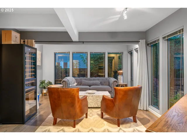 a living room with furniture a large window and glass door