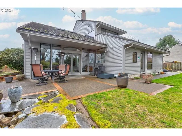 a backyard of a house with table and chairs