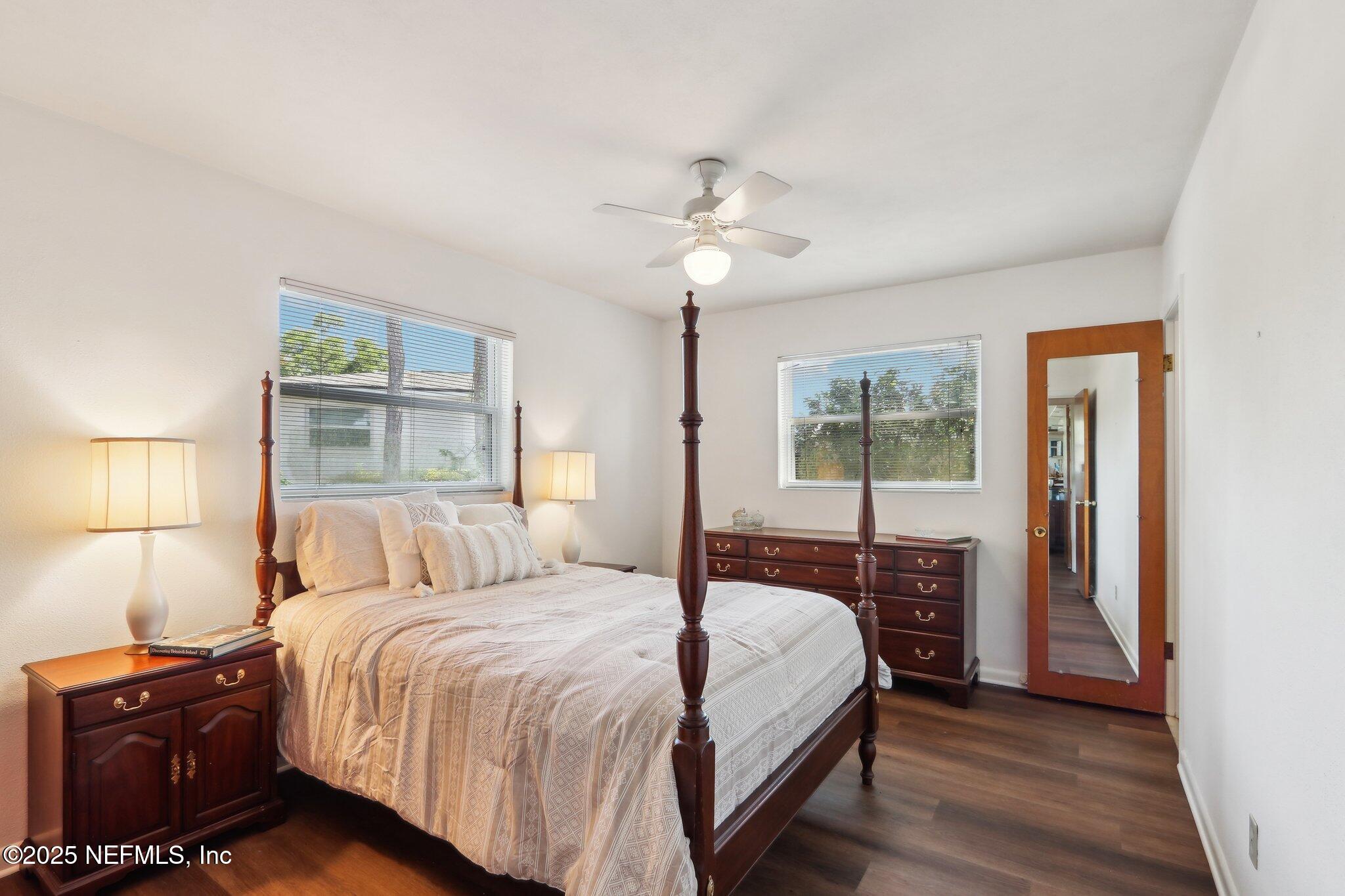 3831 Rogero Road Jacksonville, FL 32277 - Photo 14 of 33 a bedroom with a large bed and a chandelier