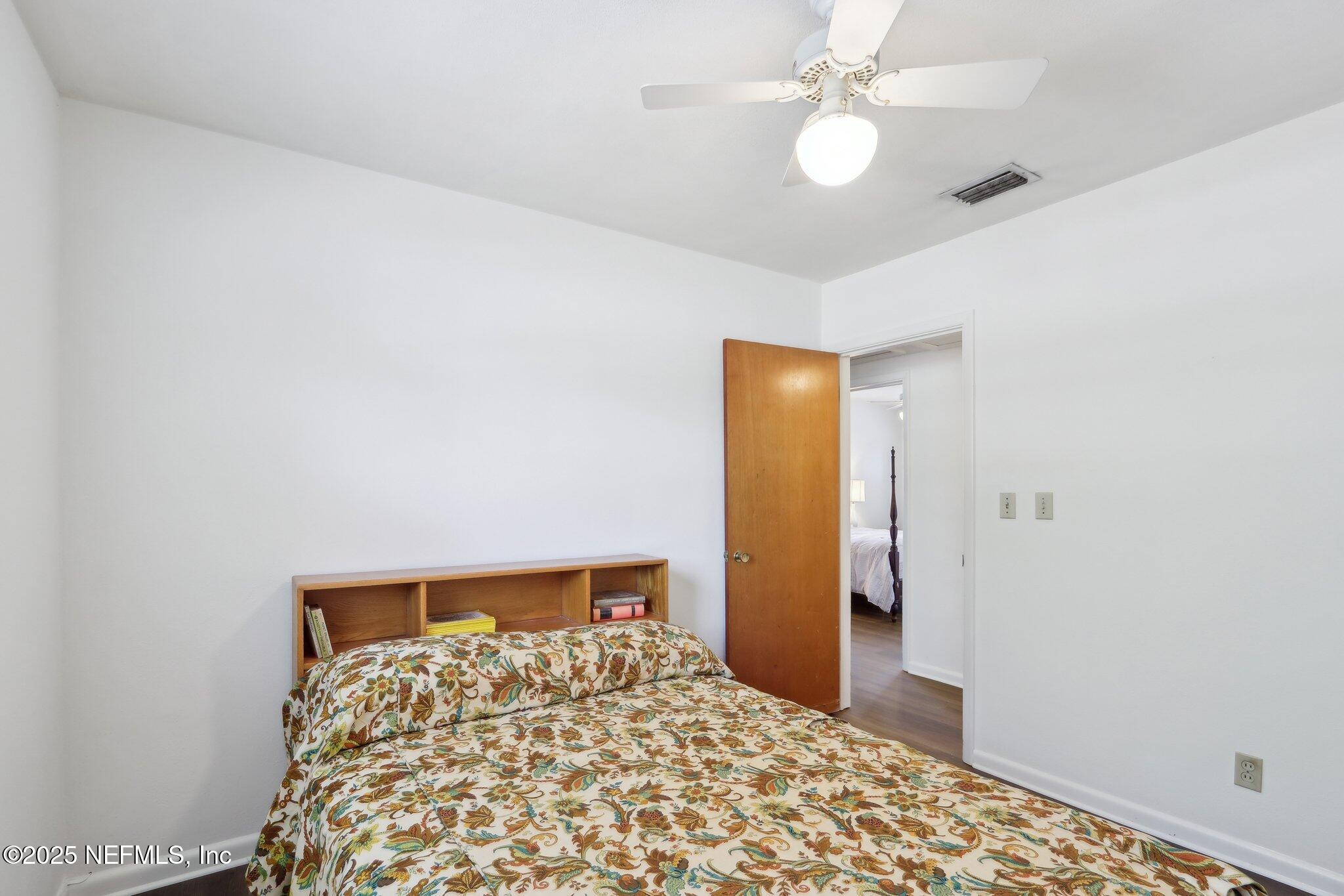 3831 Rogero Road Jacksonville, FL 32277 - Photo 23 of 33 a bedroom with a bed and a chandelier