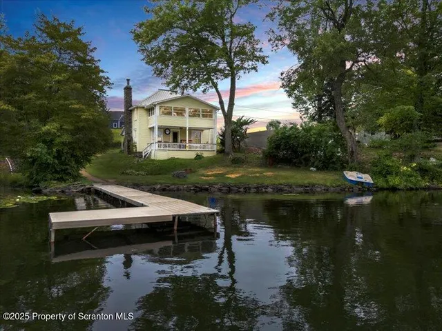 a view of swimming pool with lawn chairs and plants
