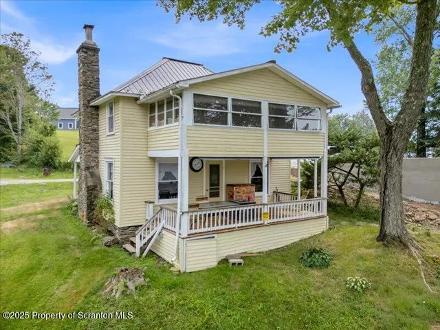 a view of a house with a yard and deck