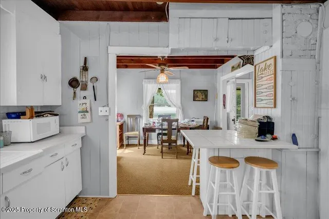 a dining hall with stainless steel appliances granite countertop a stove a sink dishwasher and cabinets with wooden floor