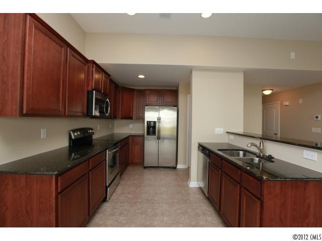 2203 Durand Road, Unit 79 Fort Mill, SC 29715 - Photo 2 of 12 a kitchen with granite countertop stainless steel appliances a sink stove and refrigerator