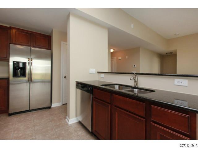 2203 Durand Road, Unit 79 Fort Mill, SC 29715 - Photo 4 of 12 a kitchen with granite countertop stainless steel appliances a sink and a refrigerator