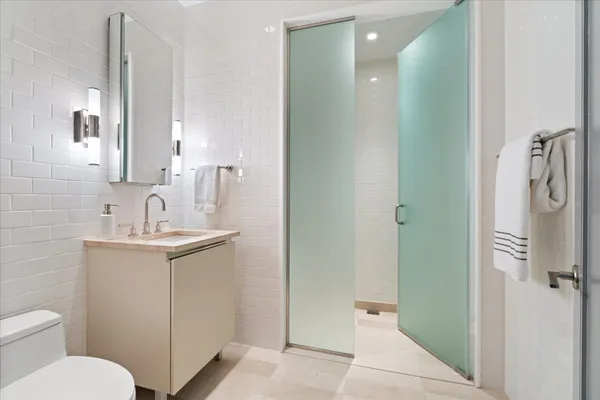 a bathroom with a toilet sink and mirror