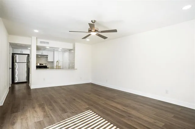 a view of a kitchen with wooden floor and a ceiling fan