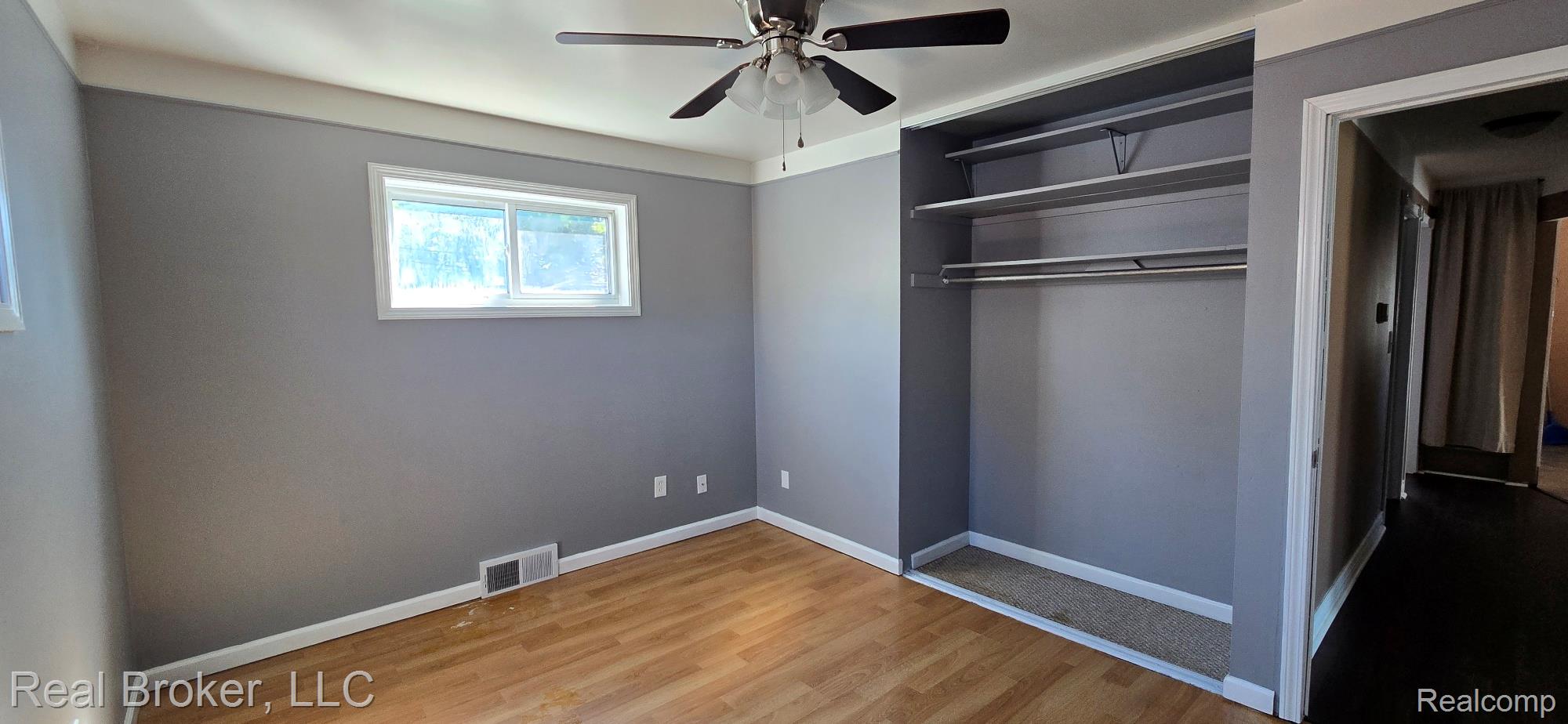 23401 Filmore Street Taylor, MI 48180 - Photo 10 of 16 Room featuring wood-finish flooring, a ceiling fan with integrated lighting, and a built-in closet with shelving and hanging rods