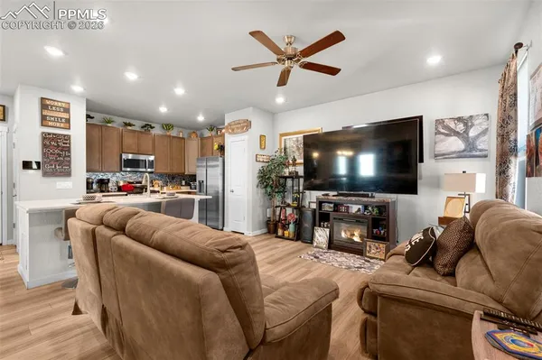 a living room with furniture and a flat screen tv with kitchen view