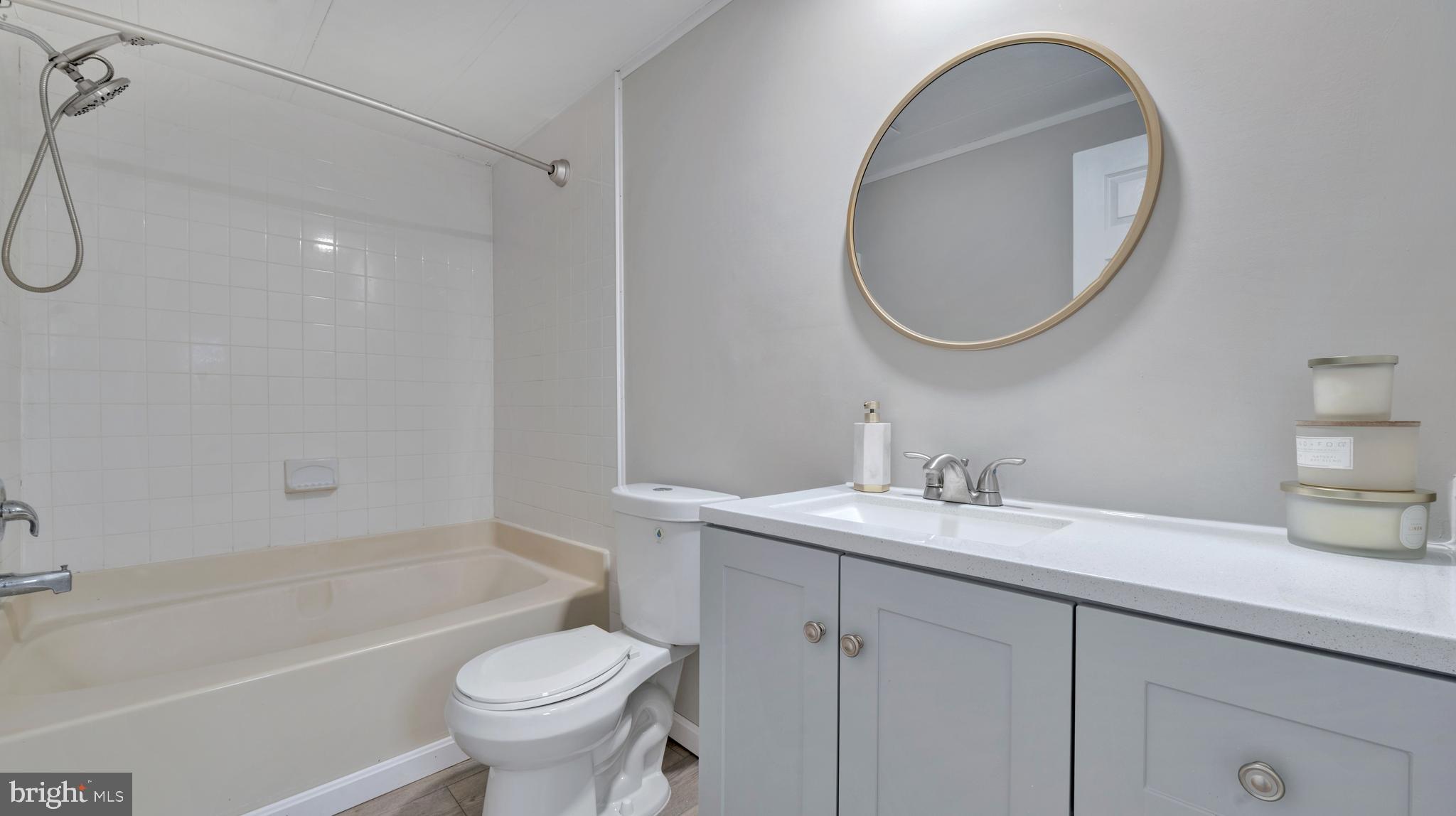 276 5th Street Lothian, MD 20711 - Photo 12 of 18 a bathroom with a granite countertop toilet a sink and a mirror