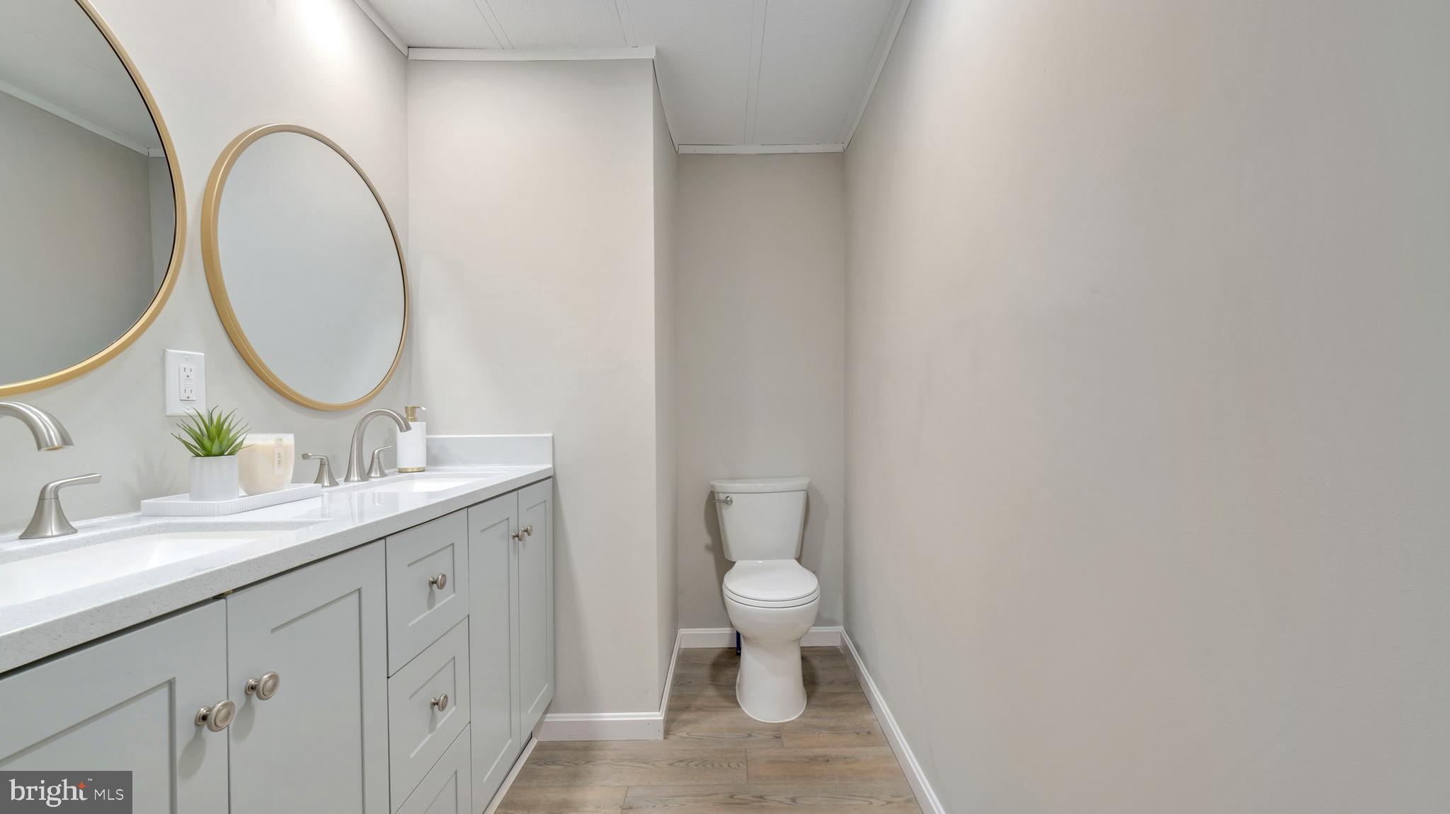 276 5th Street Lothian, MD 20711 - Photo 13 of 18 a bathroom with a granite countertop toilet a sink and a mirror