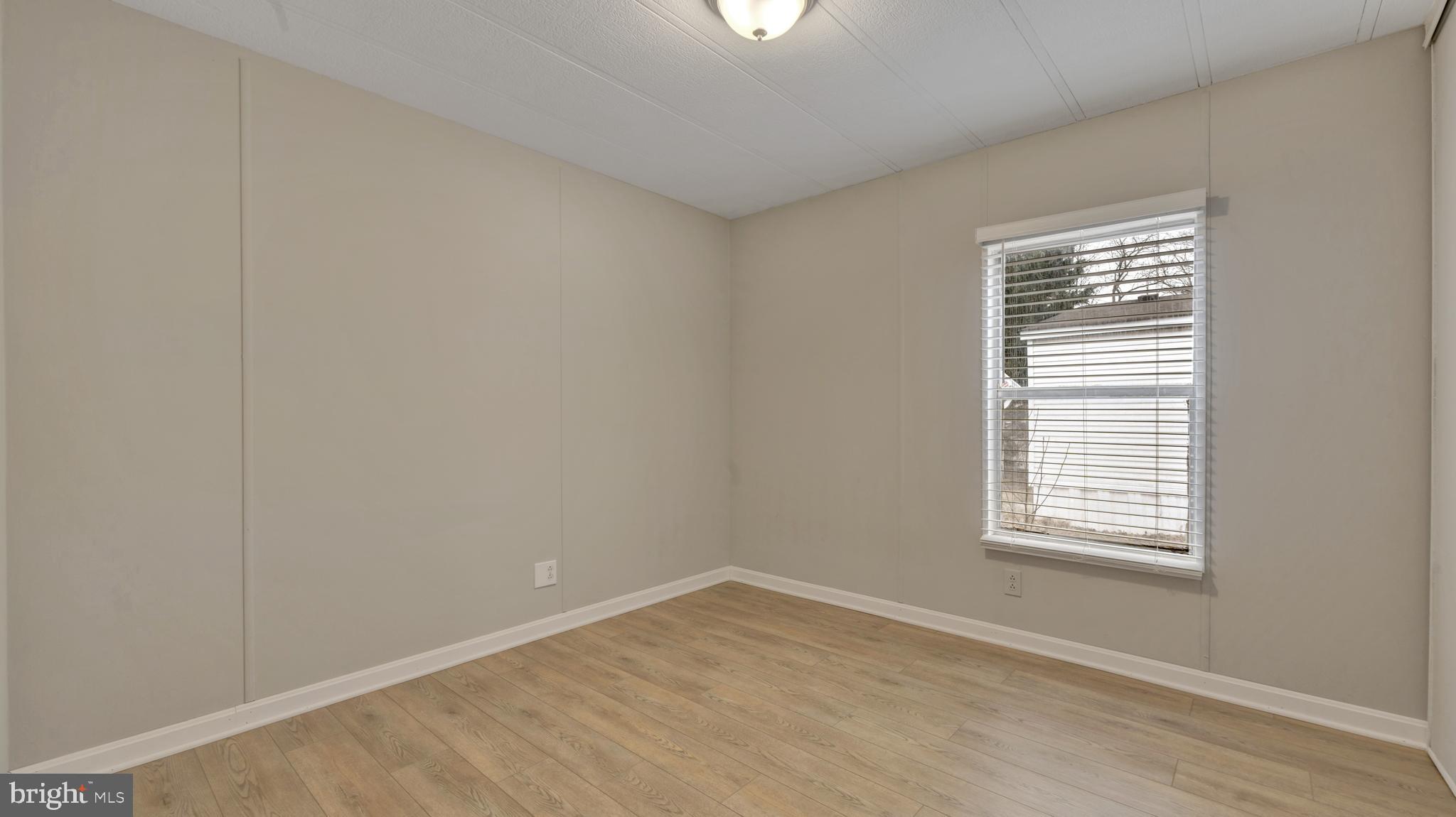 276 5th Street Lothian, MD 20711 - Photo 14 of 18 a view of an empty room with wooden floor and a window