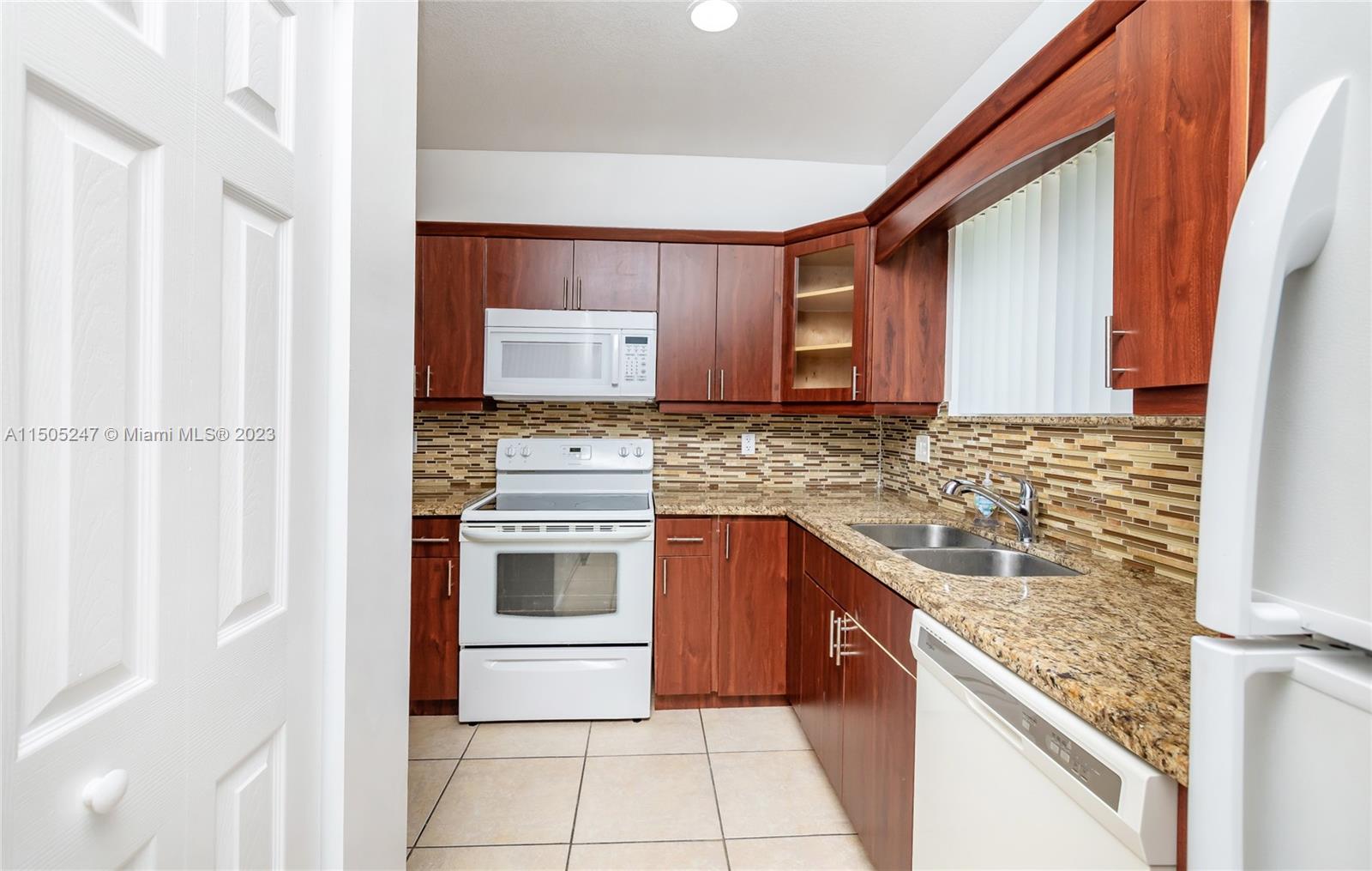 3501 Northeast 4th Street, Unit 3501 Homestead, FL 33033 - Photo 11 of 44 a kitchen with stainless steel appliances granite countertop a stove a sink and a microwave