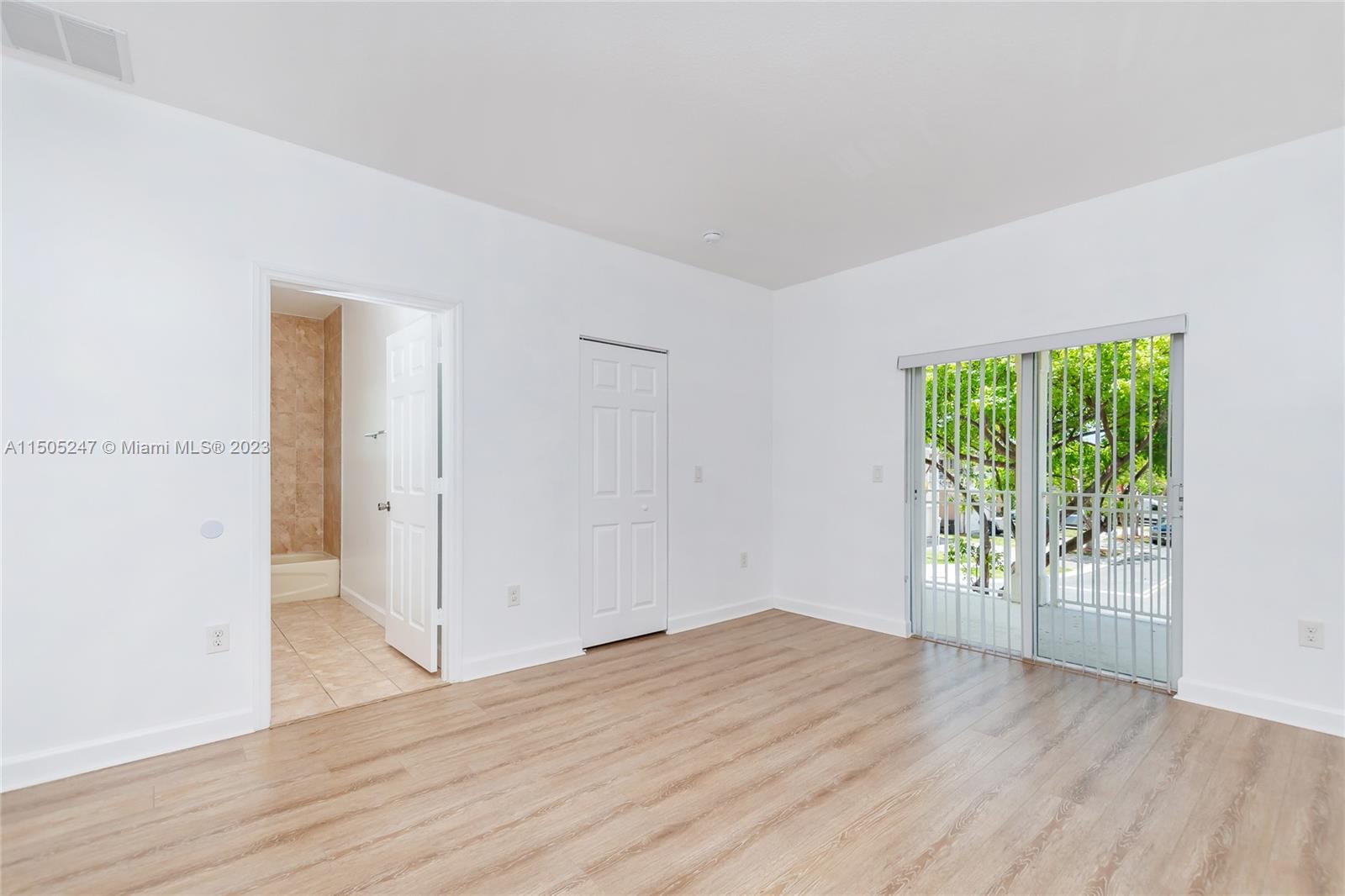 3501 Northeast 4th Street, Unit 3501 Homestead, FL 33033 - Photo 32 of 44 an empty room with wooden floor and windows