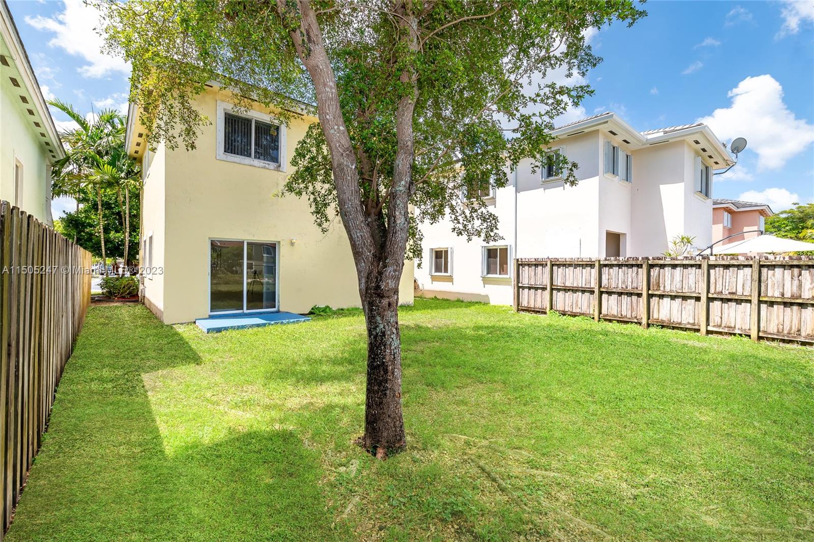 3501 Northeast 4th Street, Unit 3501 Homestead, FL 33033 - Photo 7 of 44 a view of a white house in front of a big yard with large trees