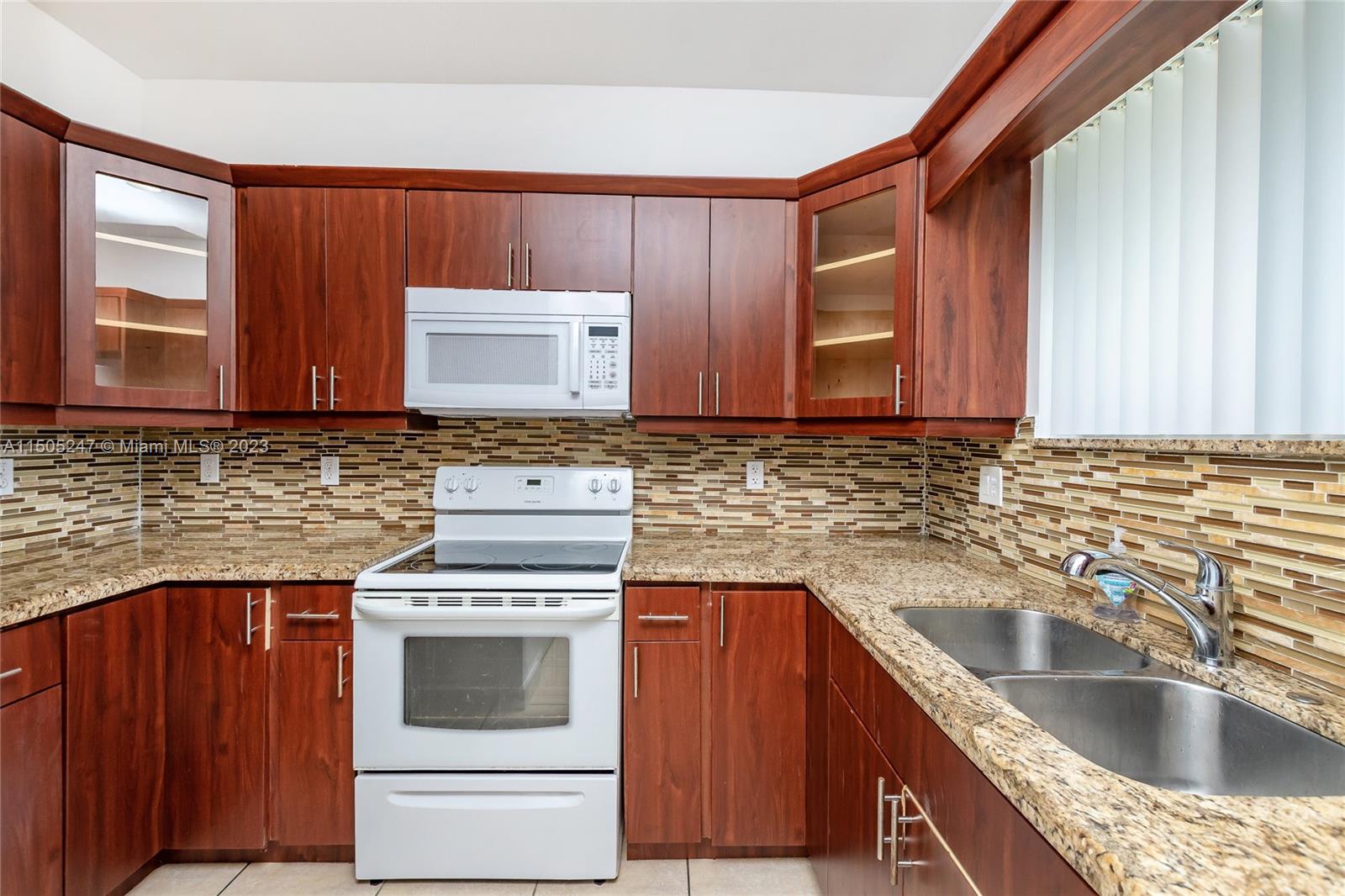 3501 Northeast 4th Street, Unit 3501 Homestead, FL 33033 - Photo 10 of 44 a kitchen with granite countertop stainless steel appliances wooden cabinet and a stove top oven