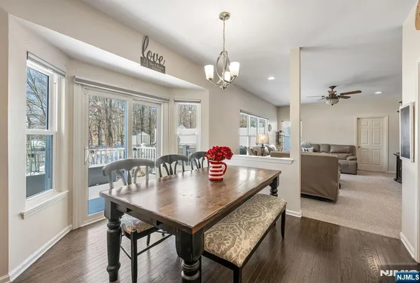 a view of a dining room and livingroom with furniture wooden floor a chandelier